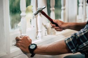The carpenter holds the hammer and nails.