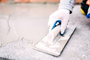 industrial worker on construction site laying sealant for waterproofing cement