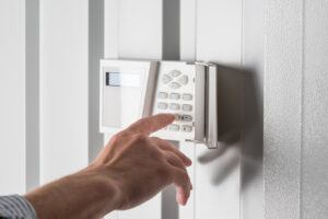 security installer typing on keypad of home security alarm