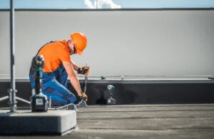 Security installer installing a security system on a commercial roof