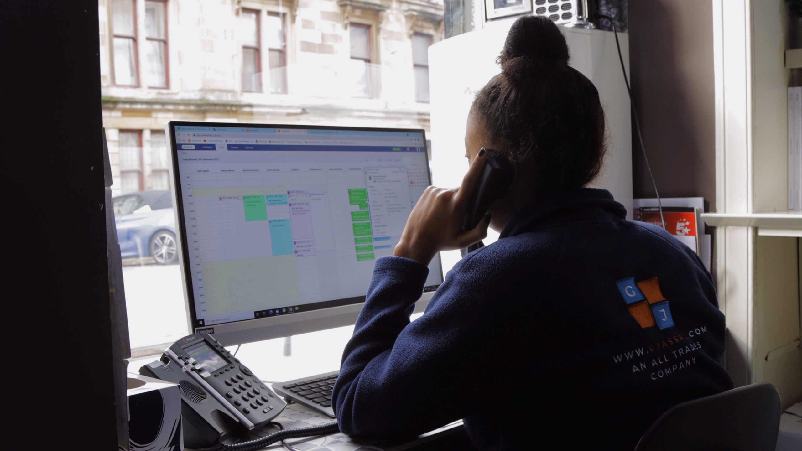 Woman on the phone using Commusoft in the office