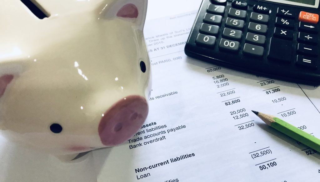 list of financial mistakes a roofing business made with a piggybank next to it
