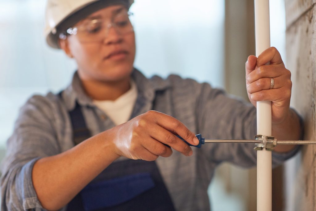 woman plumber cutting a pipe