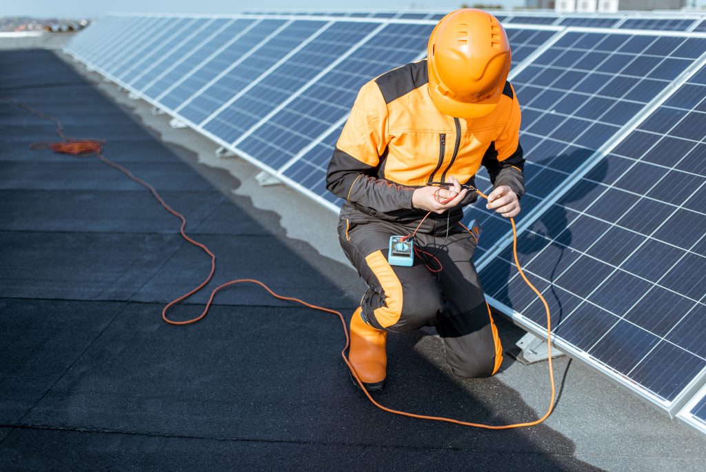 field service technician installs solar panels with renewable energy software